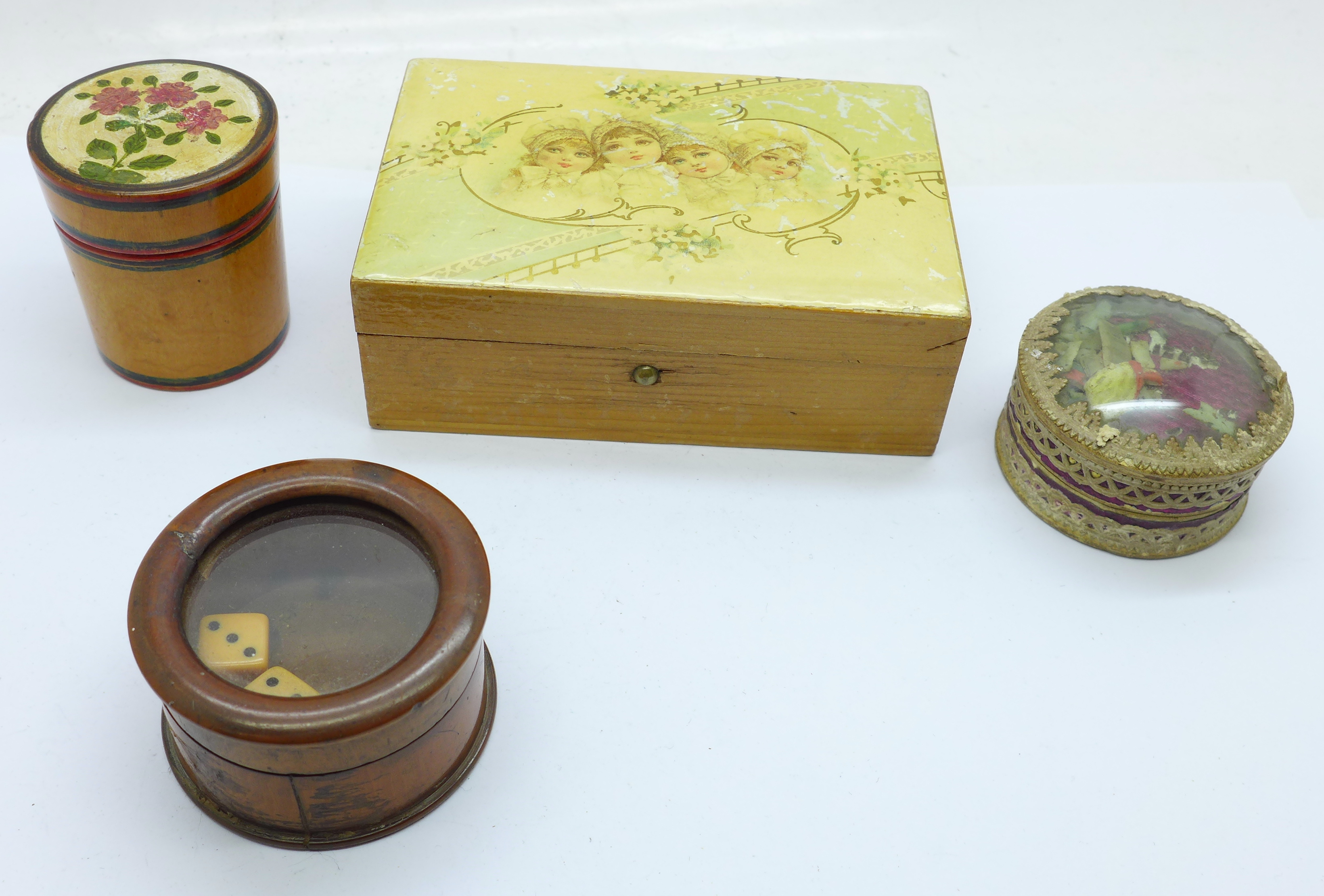 Three treen items including a dice shaker and a circular box depicting a religious scene in the