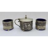 A silver three piece cruet set with eastern scene, Birmingham 1911/12, one mark worn, 79g