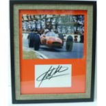 A framed photograph of John Surtees with mounted autograph