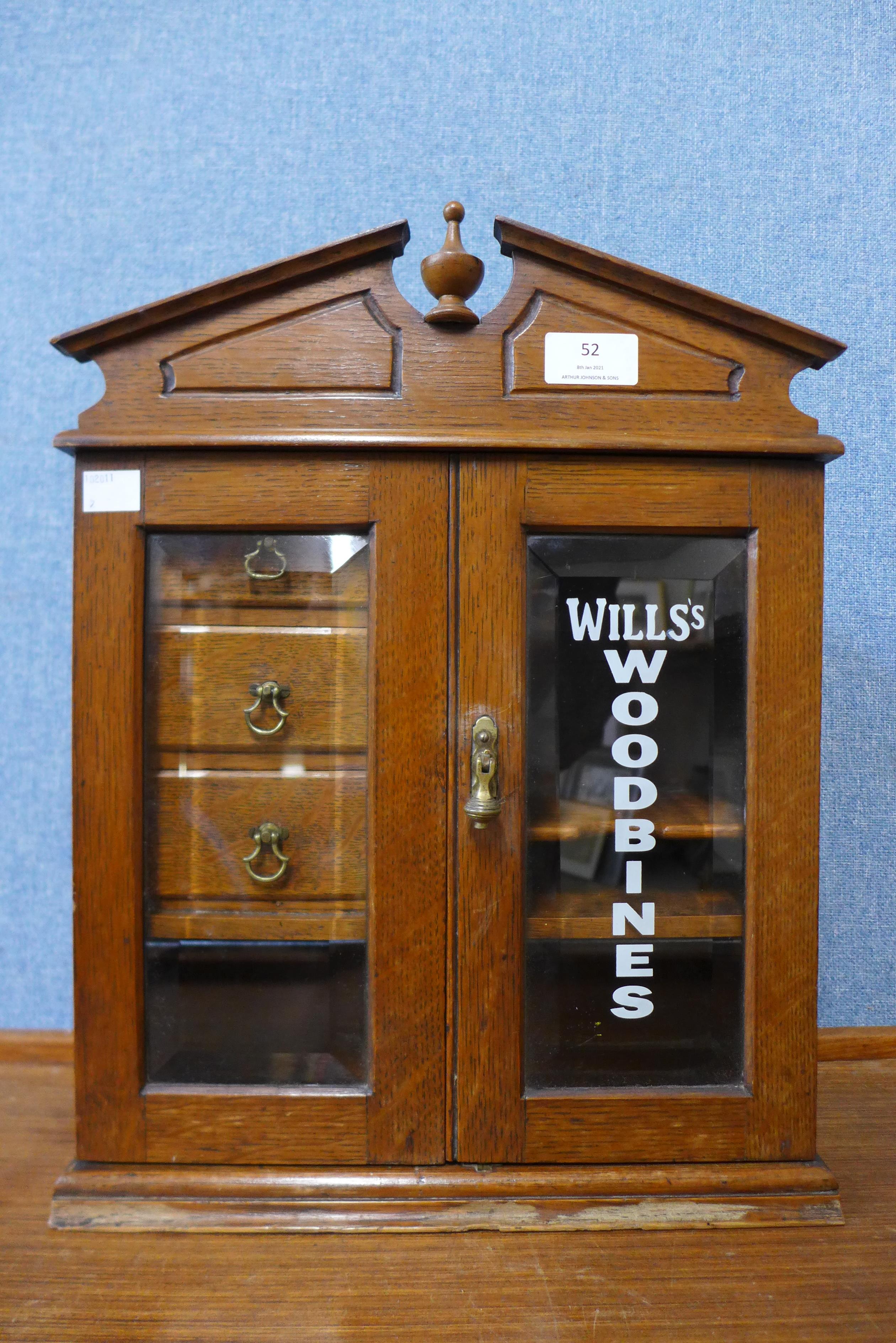 An oak smokers cabinet, bearing Wills Woodbines inscription