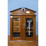 An oak smokers cabinet, bearing Wills Woodbines inscription
