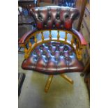 A beech and red leather revolving desk chair