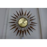 A teak and brass sunburst wall clock