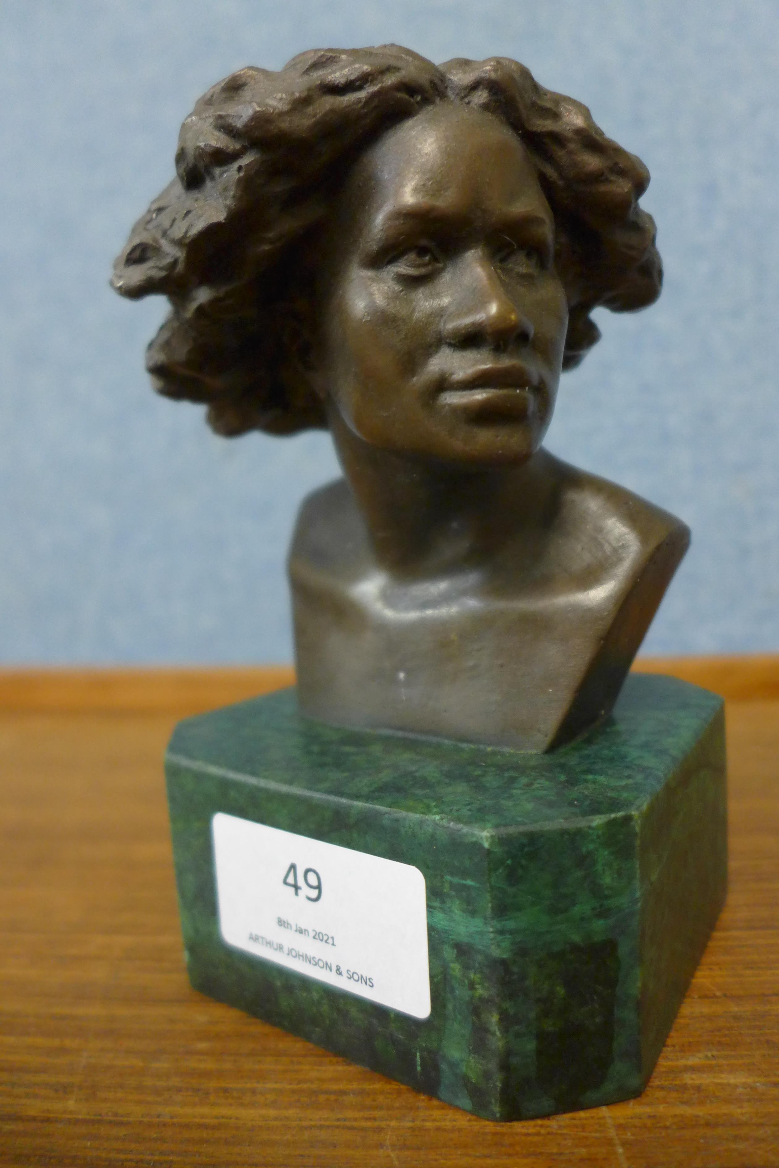 A French style bronze bust of a woman, on green marble socle, 14cms h