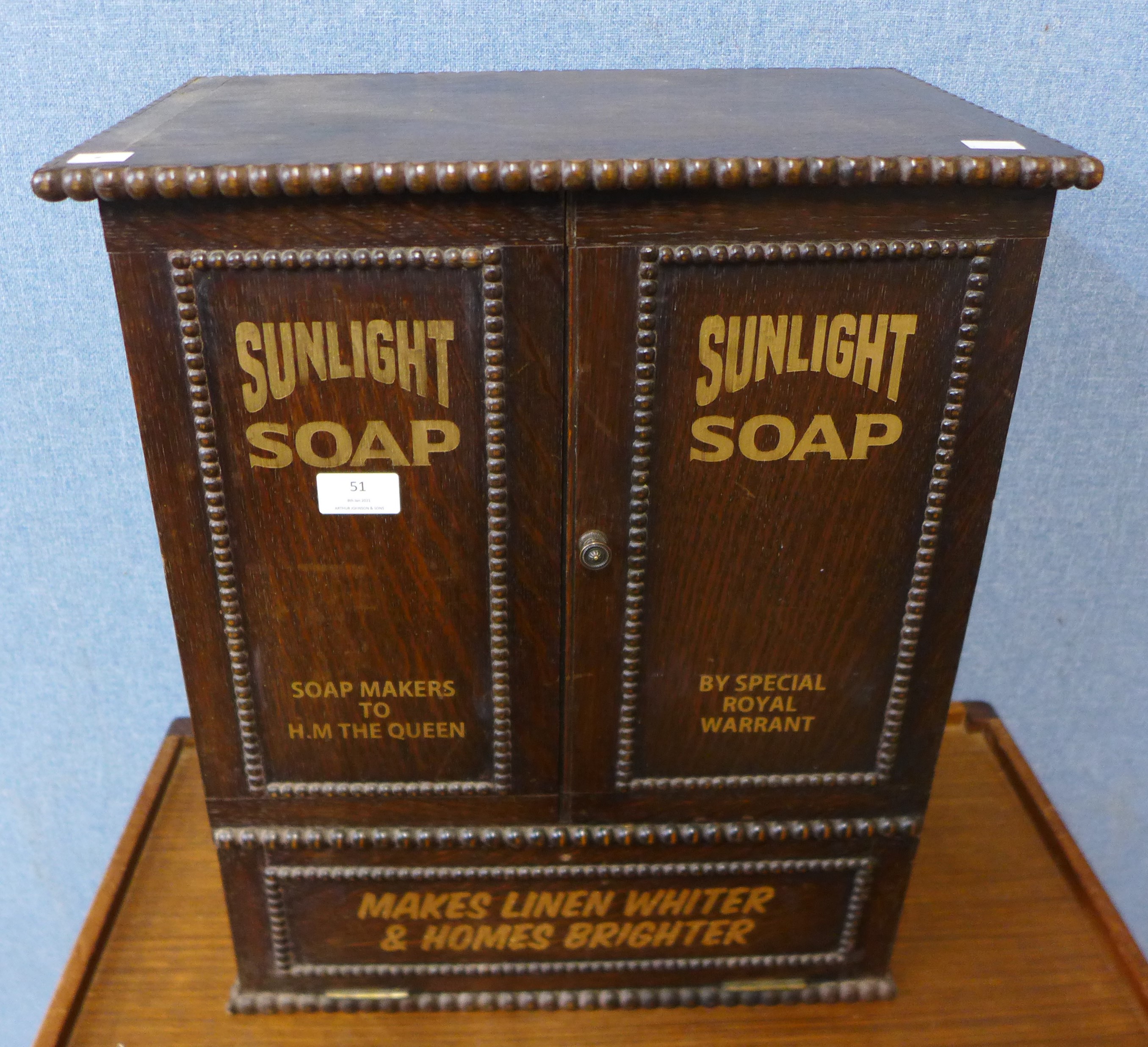 An oak table top shop cabinet, bearing Sunlight Soap inscription to doors