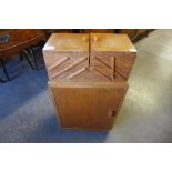 An Art Deco light oak metamorphic sewing cabinet