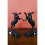 A pair of bronze boxing hares, on black marble plinths, 30cms h
