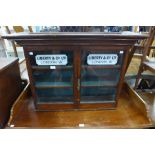 A beech two door table top cabinet, bearing Liberty & Co. inscription to doors