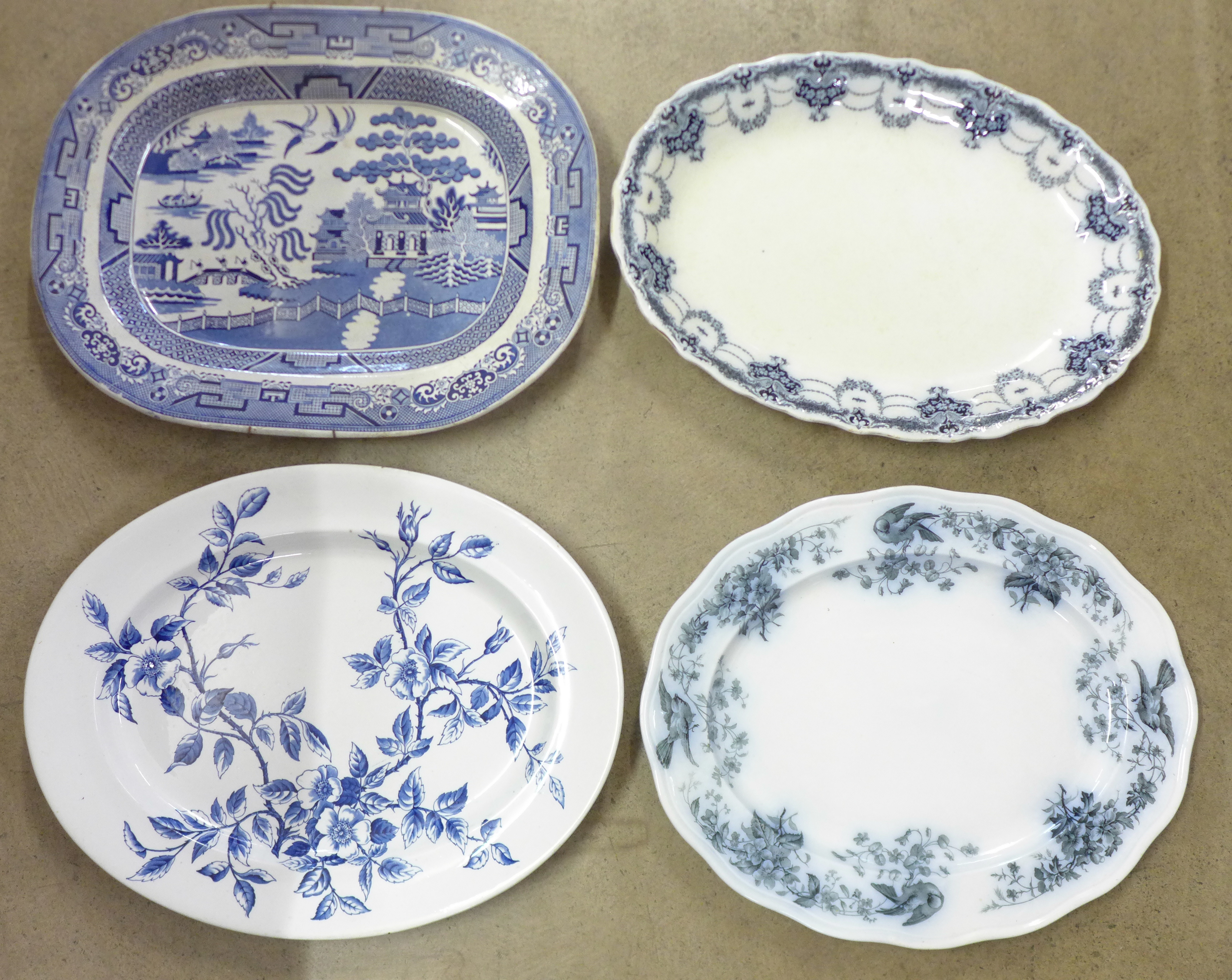 A large blue and white Willow pattern meat plate and three other meat plates, a/f