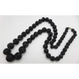 A carved Whitby jet bead necklace, 71cm