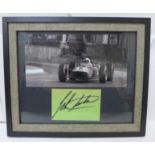 A framed photograph of John Surtees with mounted autograph