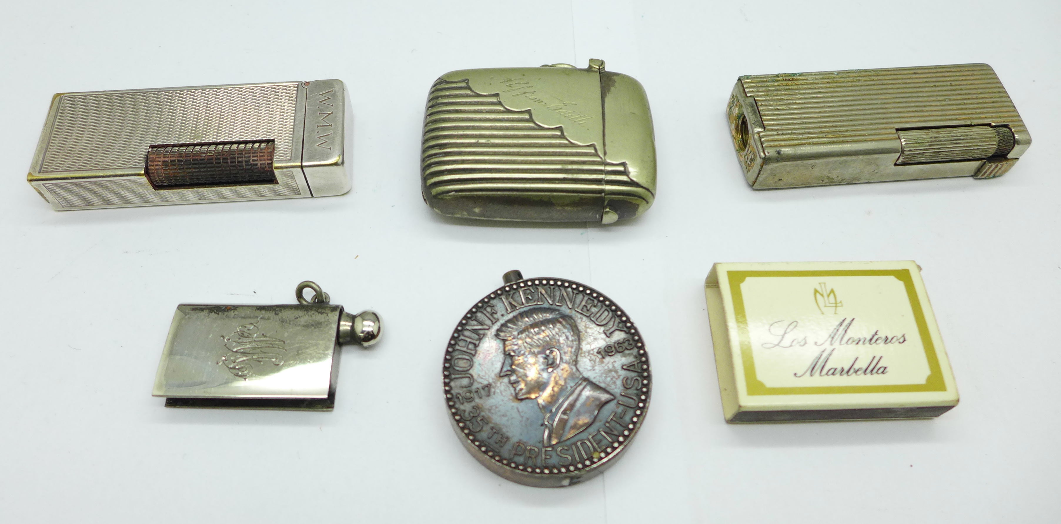 Three lighters including Dunhill, with initials, and novelty John F. Kennedy, a vesta case, etc.,