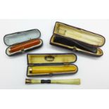 Two amber cheroot holders, cased, one a/f, a Bakelite cheroot holder, cased, and one other, a/f