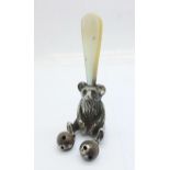 A hallmarked silver and mother of pearl Teddy bear rattle, Crisford & Norris, worn Birmingham date
