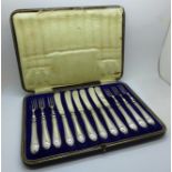 A set of six dessert knives and forks with silver covered handles, in a fitted case, Sheffield 1914