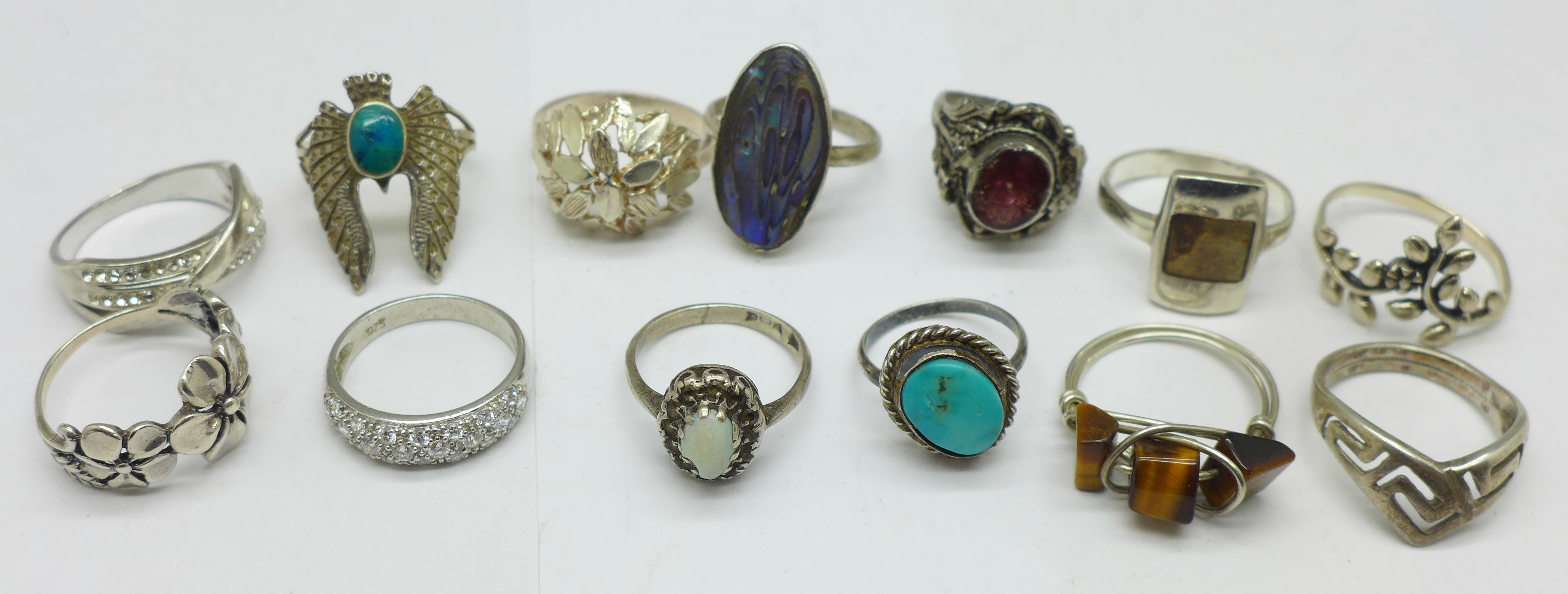 Thirteen rings;-ten silver, (one opal set a/f), and three white metal including tigers eye set