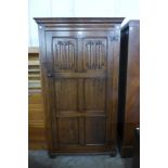 A carved Ipswich oak linenfold wardrobe