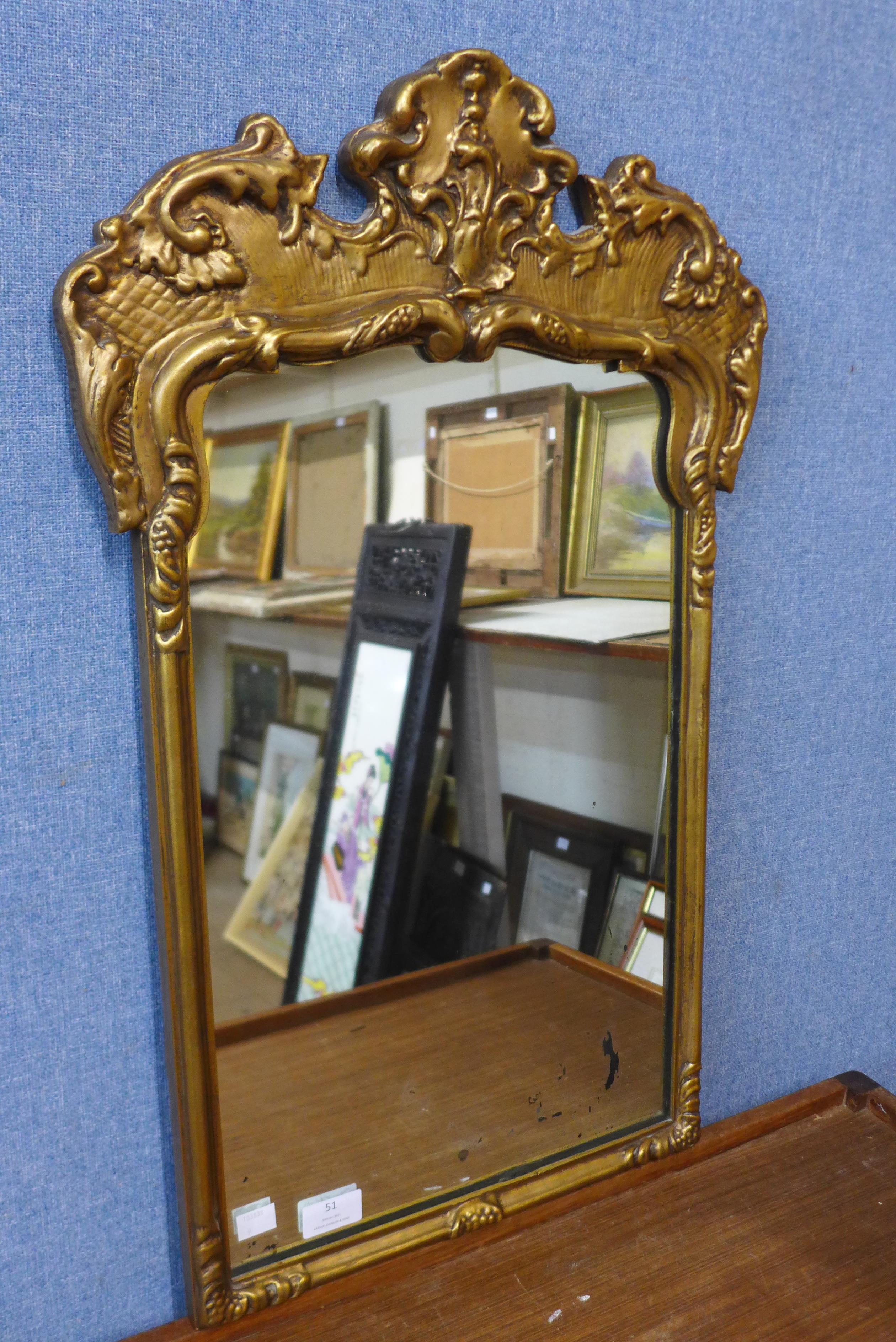 A rococo style gilt framed mirror, 69cms h