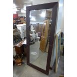 A large brown leather framed mirror