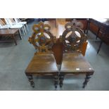 A pair of Victorian carved oak hall chairs