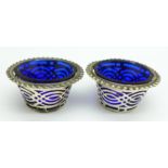 A pair of silver salts with blue glass liners