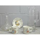 A Wedgwood Peter Rabbit plate and two mugs, a glass decanter and tall glass jug **PLEASE NOTE THIS