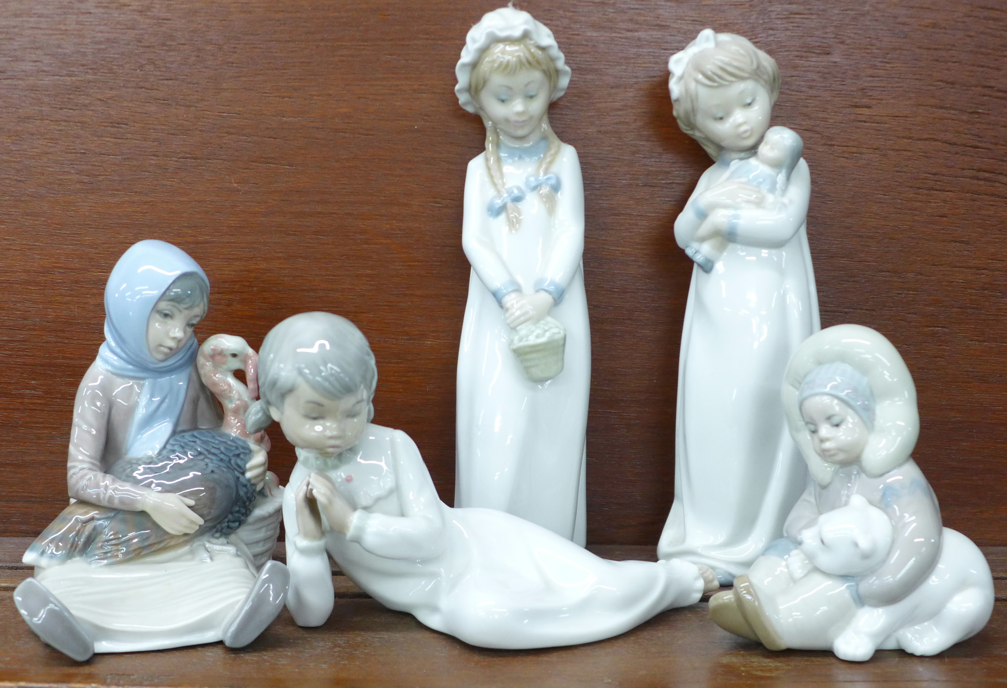 Two Lladro figures, Eskimo with polar bear cub and Girl holding a turkey plus three other Spanish