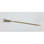 A yellow and white metal set diamond Art Deco stick pin, set with a brilliant cut diamond and four