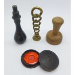 A wooden desk seal, a brass desk seal, a wax seal in a circular box and a seal handle