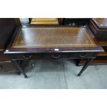 A mahogany and brown leather topped three drawer writing table