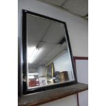 A black and silver effect framed mirror