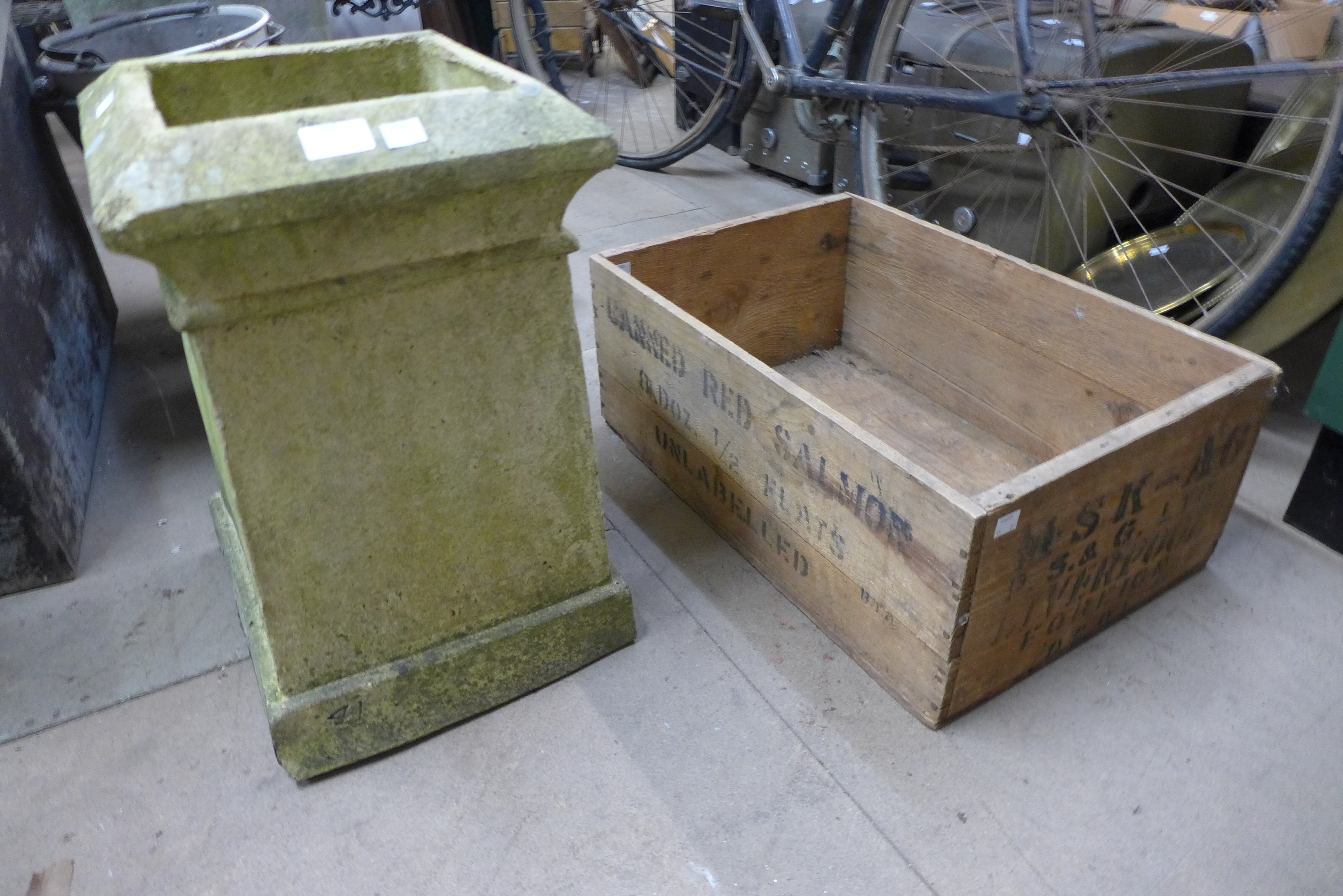 A concrete chimney pot and a wooden advertising crate