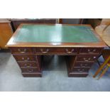 A mahogany and green leather topped pedestal desk
