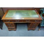 A yew wood and green leather topped pedestal desk