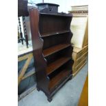 A mahogany open waterfall front bookcase