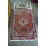An eastern red ground geometric pattern rug, 155 x 109cms and another small cream ground rug