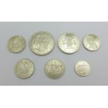 Seven coins; a 1934 half crown, a 1946 two shillings, four shillings, 1941, 1942, 1943 and 1945, and