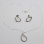 A pair of diamond set earrings and a matching pendant, the fasteners marked 750, the pendant on a