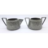 An Arts and Crafts Ashberry pewter sugar bowl and cream jug