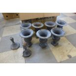 Seven small cast iron urns, some with lids