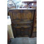 A carved oak linenfold cocktail cabinet