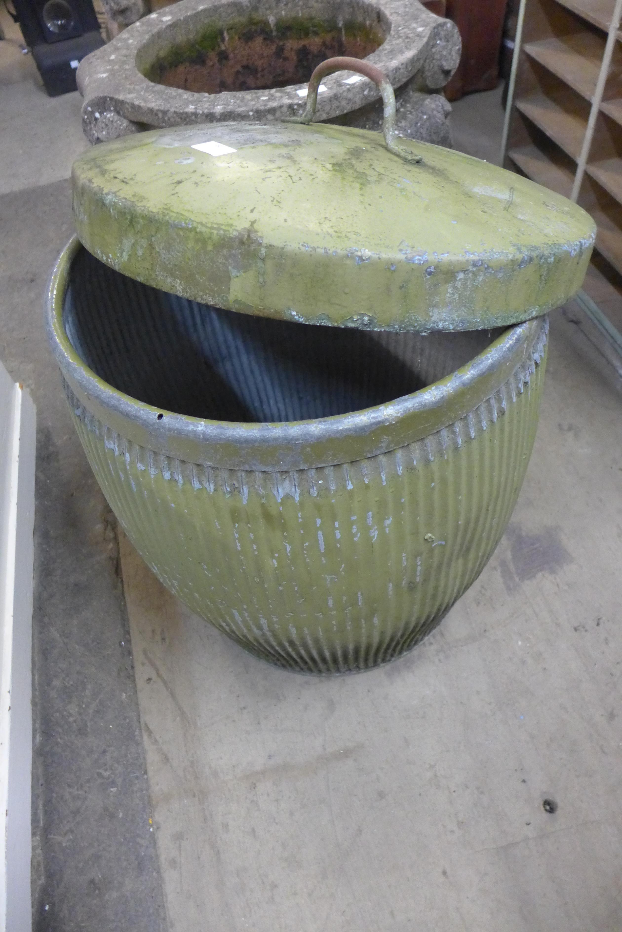 A galvanised dust bin and lid