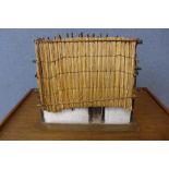 A cased model of a thatched cottage