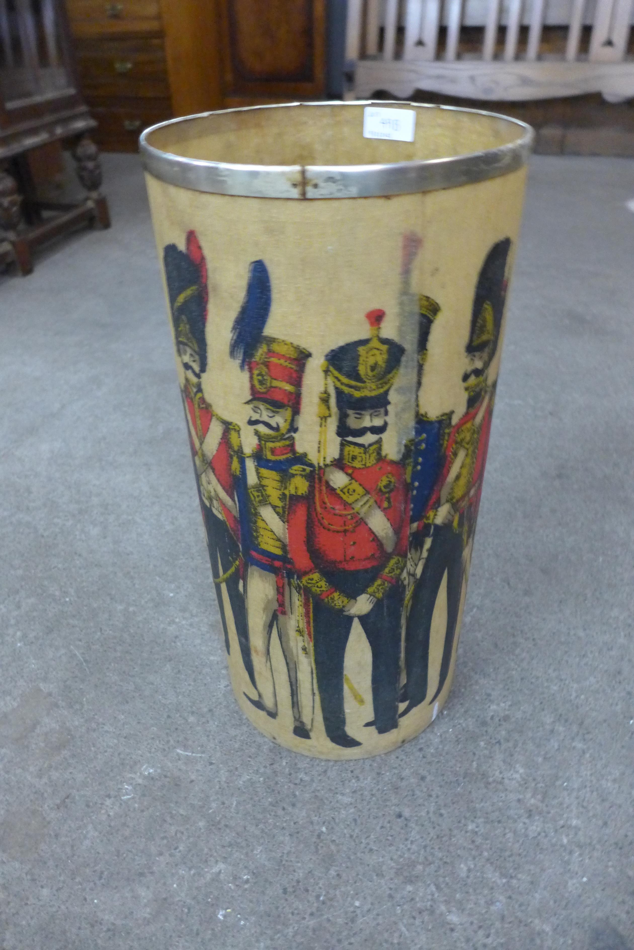 A 1960's fibre glass waste paper bin, decorated with regimental figures, 51cms h