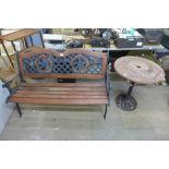 A cast iron ended garden bench and a circular garden table