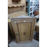 A George III oak splay front hanging corner cupboard