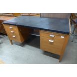 A teak and black vinyl topped desk