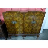 A Queen Anne style figured walnut four door cabinet on stand, 128cms h, 140cms w, 42cms d