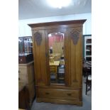 An Art Nouveau carved oak wardrobe and chest of drawers