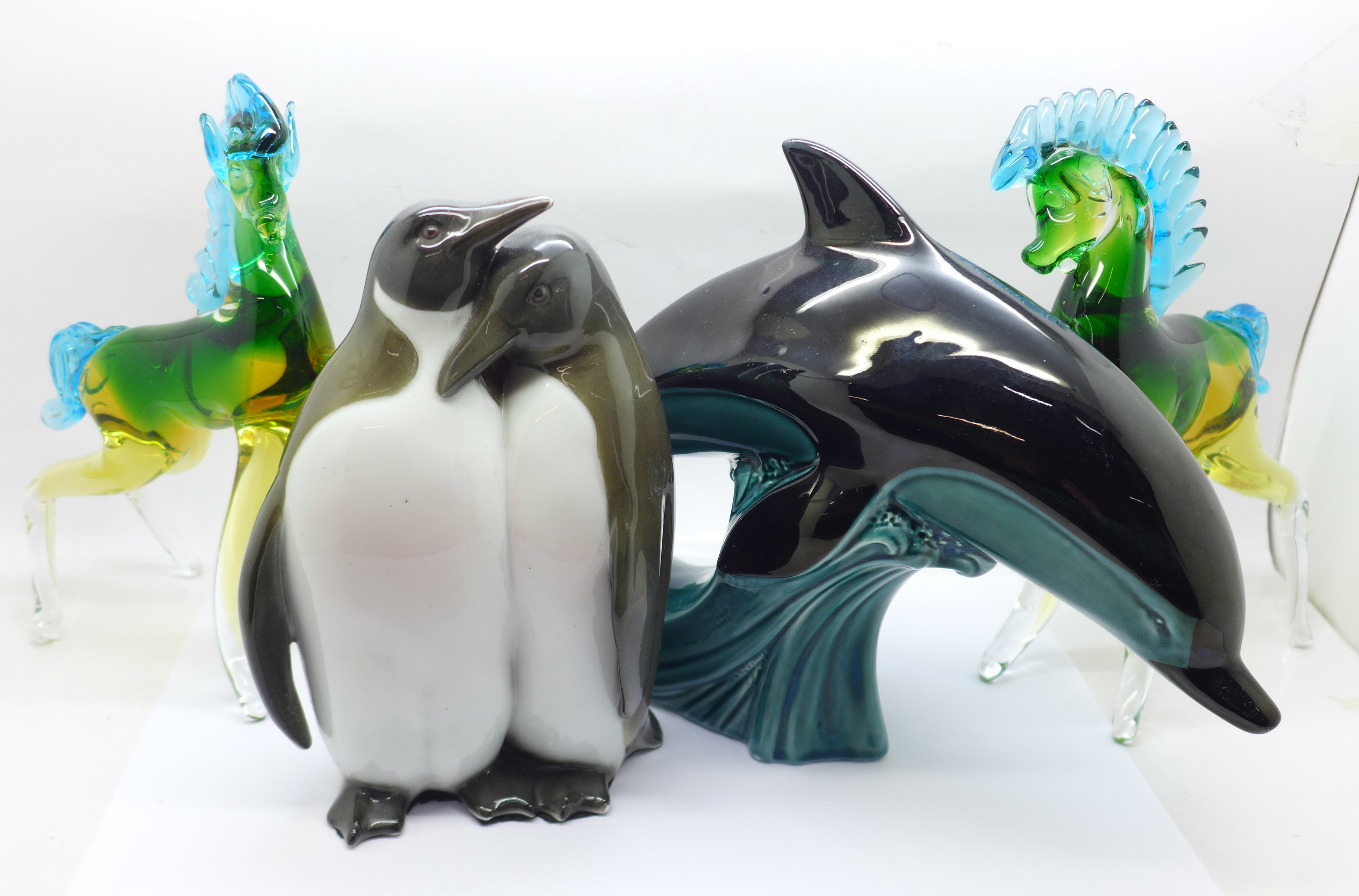 Two Murano glass models horses, a Poole dolphin and a penguin figure